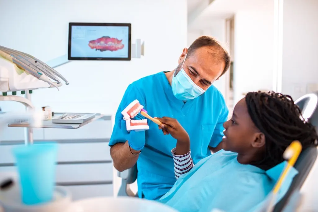 Child brushing prop teeth at the dentist