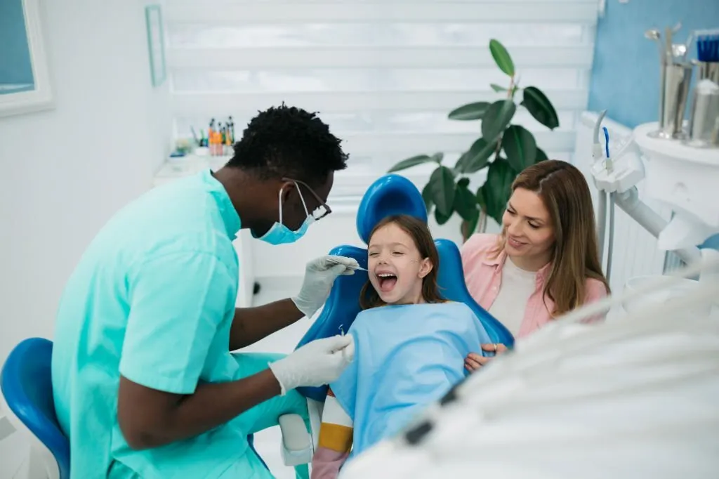 girl and mom at the dentist smiling