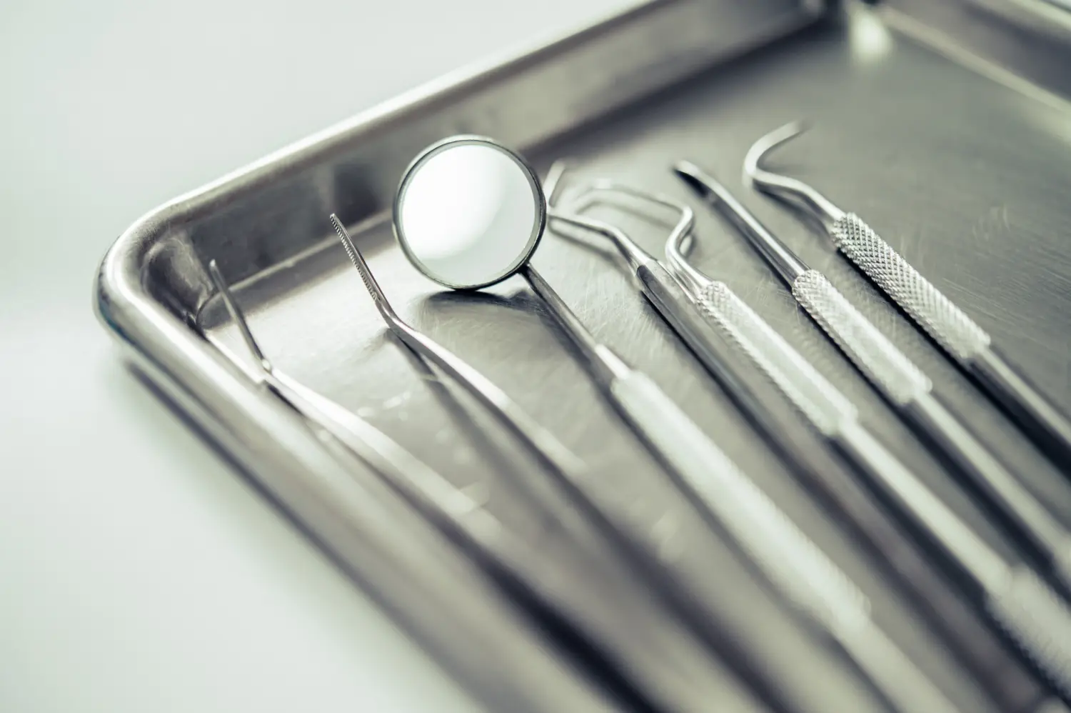 teeth cleaning tools inside a silver metal tray